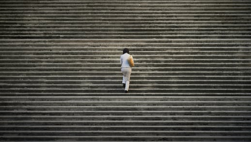 Woman walking up stairs. Photo credit: Photo by Vidar Nordli-Mathisen on Unsplash